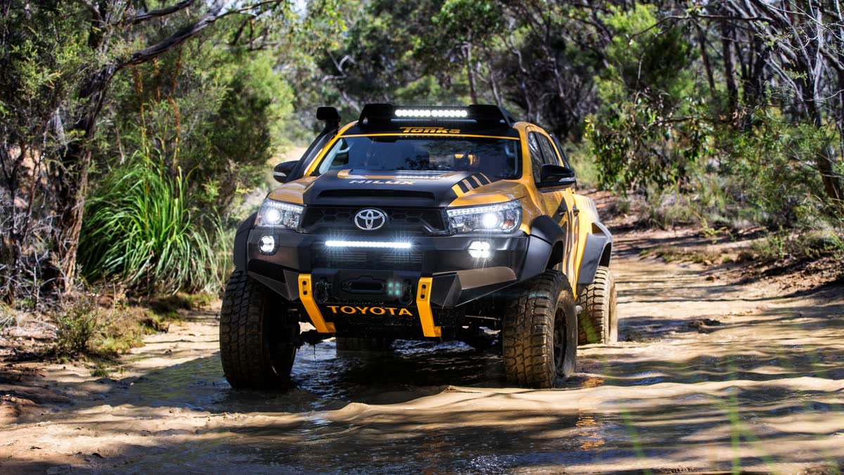 Custom lifted off-road truck build splashing through a trail