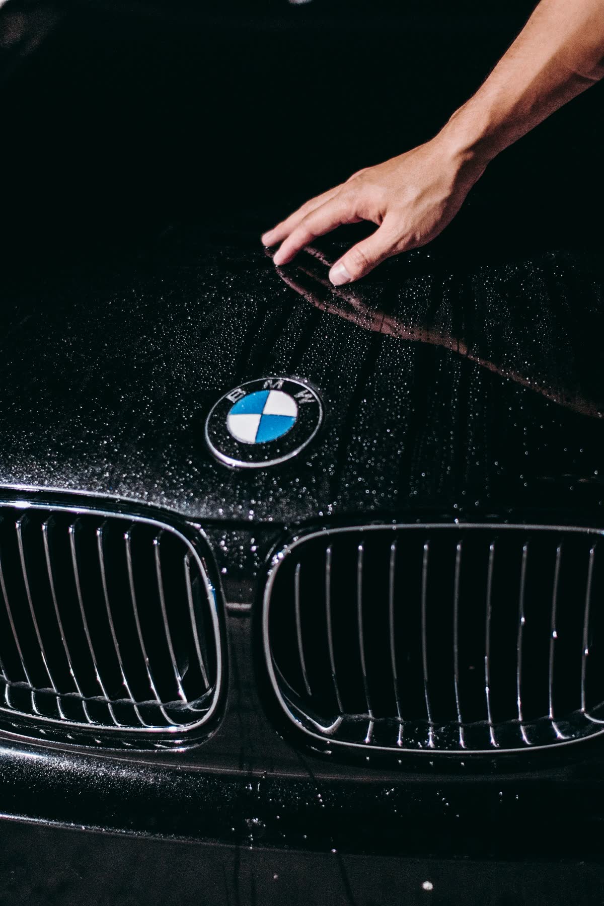 Specialist inspecting a luxury car's paintwork by hand